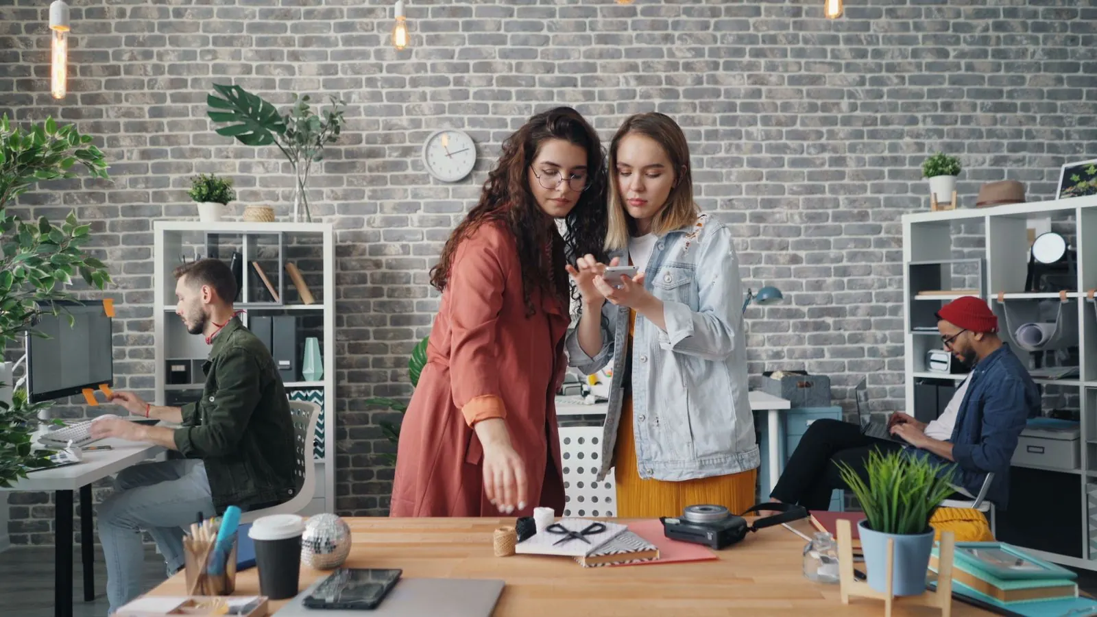 Two team members reviewing a video on a phone